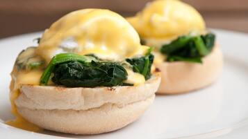 Two eggs benedict sandwiches on a white plate.