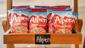A wooden display case with multiple bags of Alpen brand snacks, each labeled with the brand name and 'Original Recipe'.