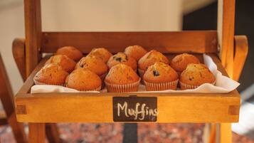 A wooden tray with muffins labeled "Muffins" on a table.