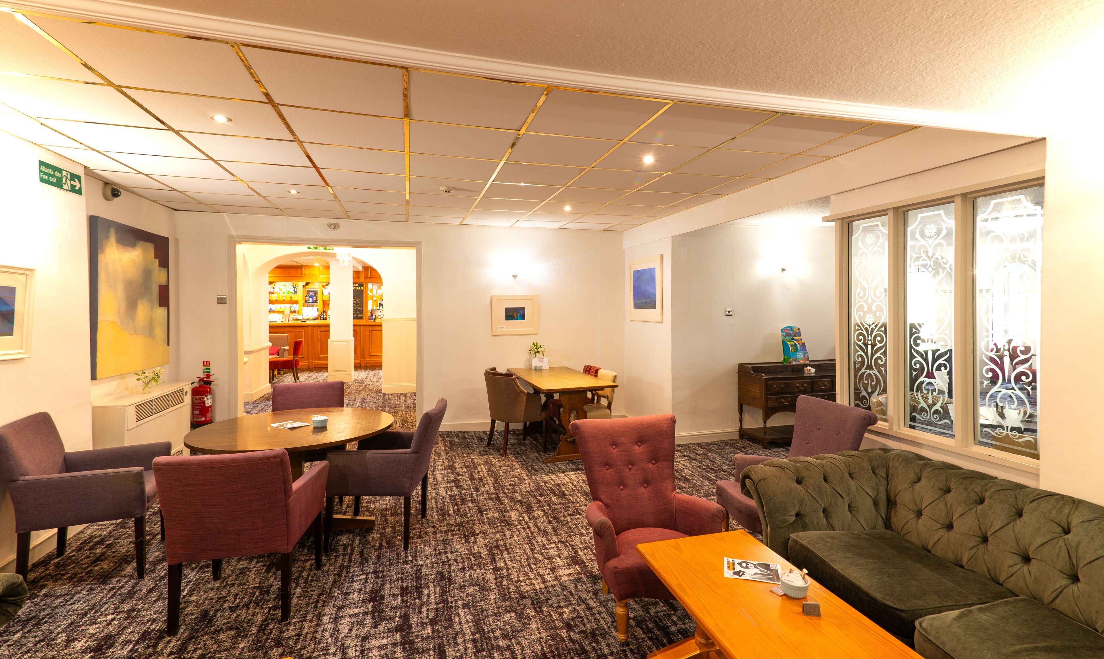 Habitación de hotel con comedor, sofá y barra.