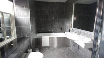 Une salle de bain moderne avec une baignoire, des toilettes et un lavabo.