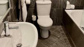 A bathroom with a sink, toilet, and bathtub.