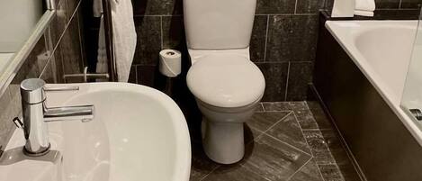 A bathroom with a sink, toilet, and bathtub.