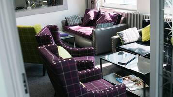 Una sala de estar moderna con un sofá, sillones y una mesa de centro.