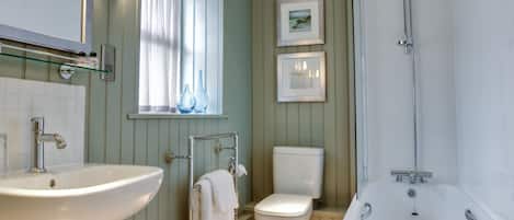 Une salle de bain avec un lavabo, des toilettes et une baignoire.