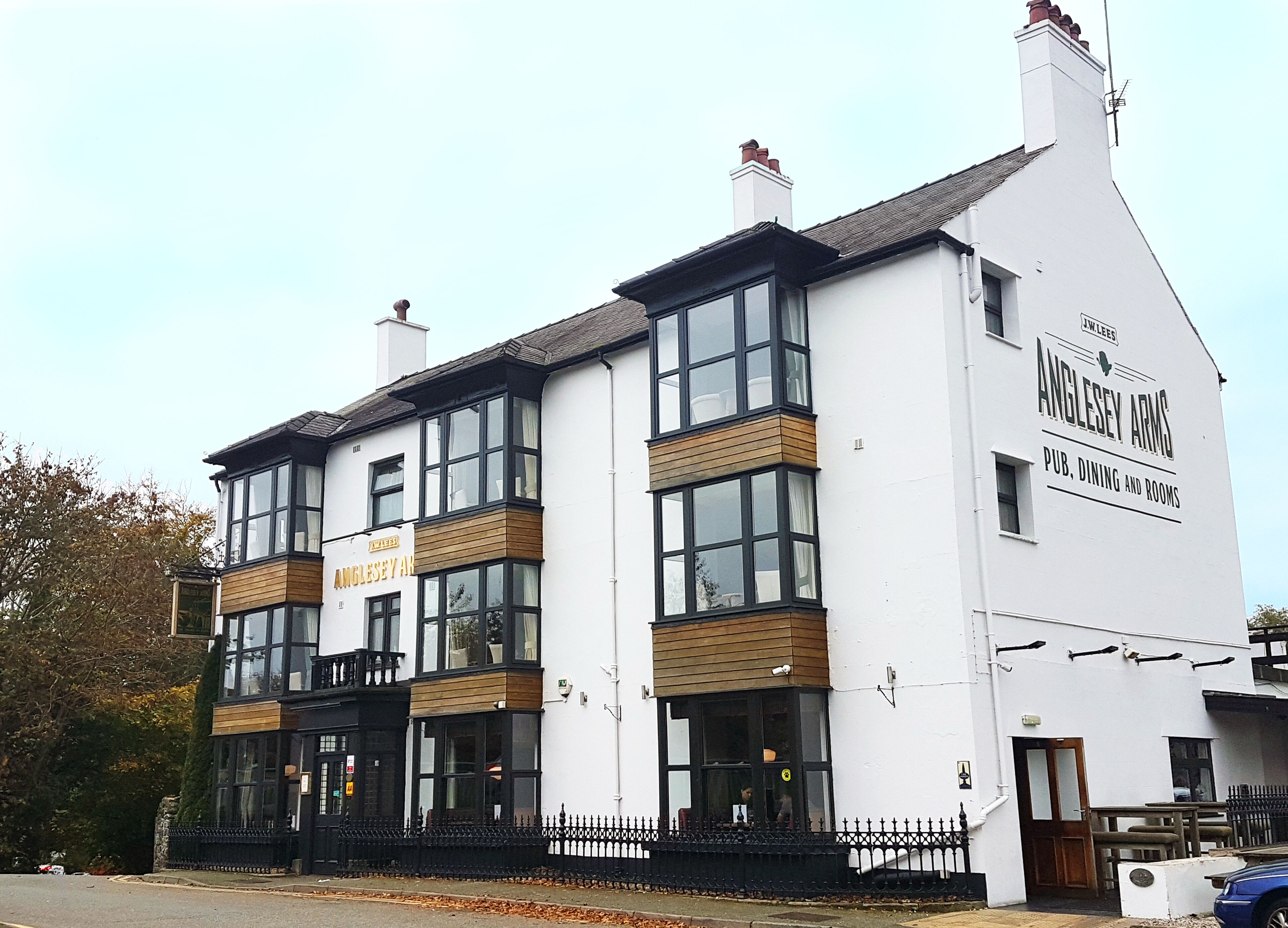 A two-story building with large windows and a sign for 'Anglesey Arms Pub, Dining and Rooms'.