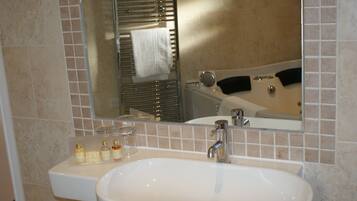 A bathroom with a sink, mirror, and bathtub.