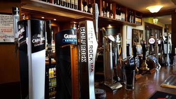 A bar with multiple taps including Guinness, Carling, and Jameson. Shelves with various bottles are visible in the background.