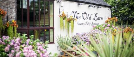 Un edificio blanco con un letrero que dice "The Old Barn Country Pub & Restaurant".