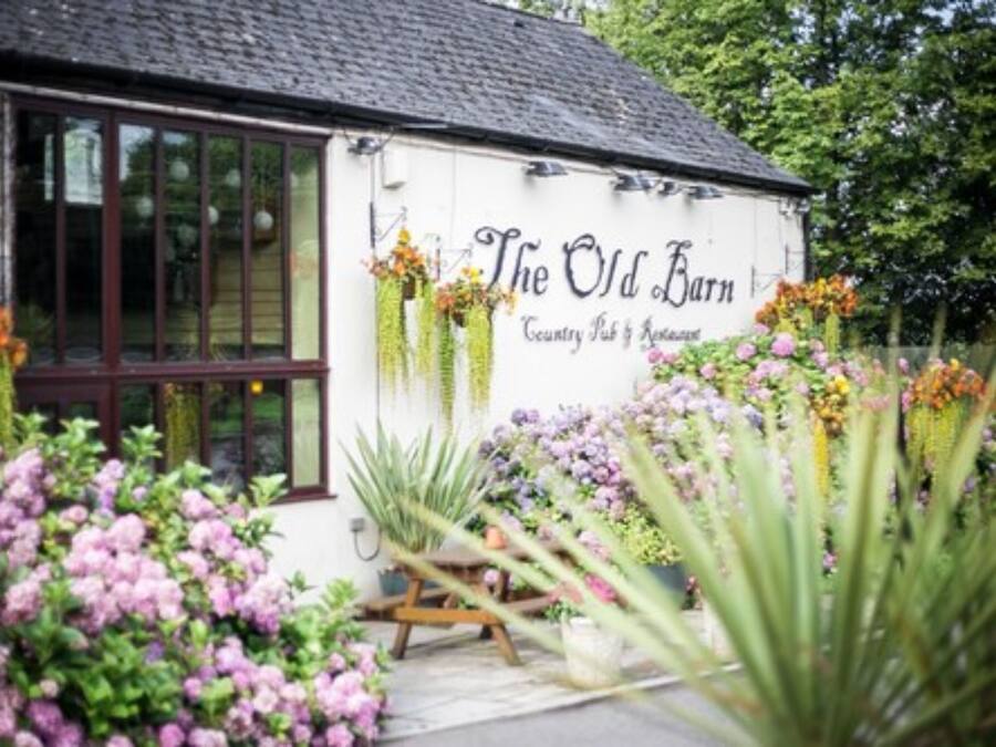 Un edificio blanco con un letrero que dice "The Old Barn Country Pub & Restaurant".