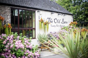 Un edificio blanco con un letrero que dice "The Old Barn Country Pub & Restaurant".