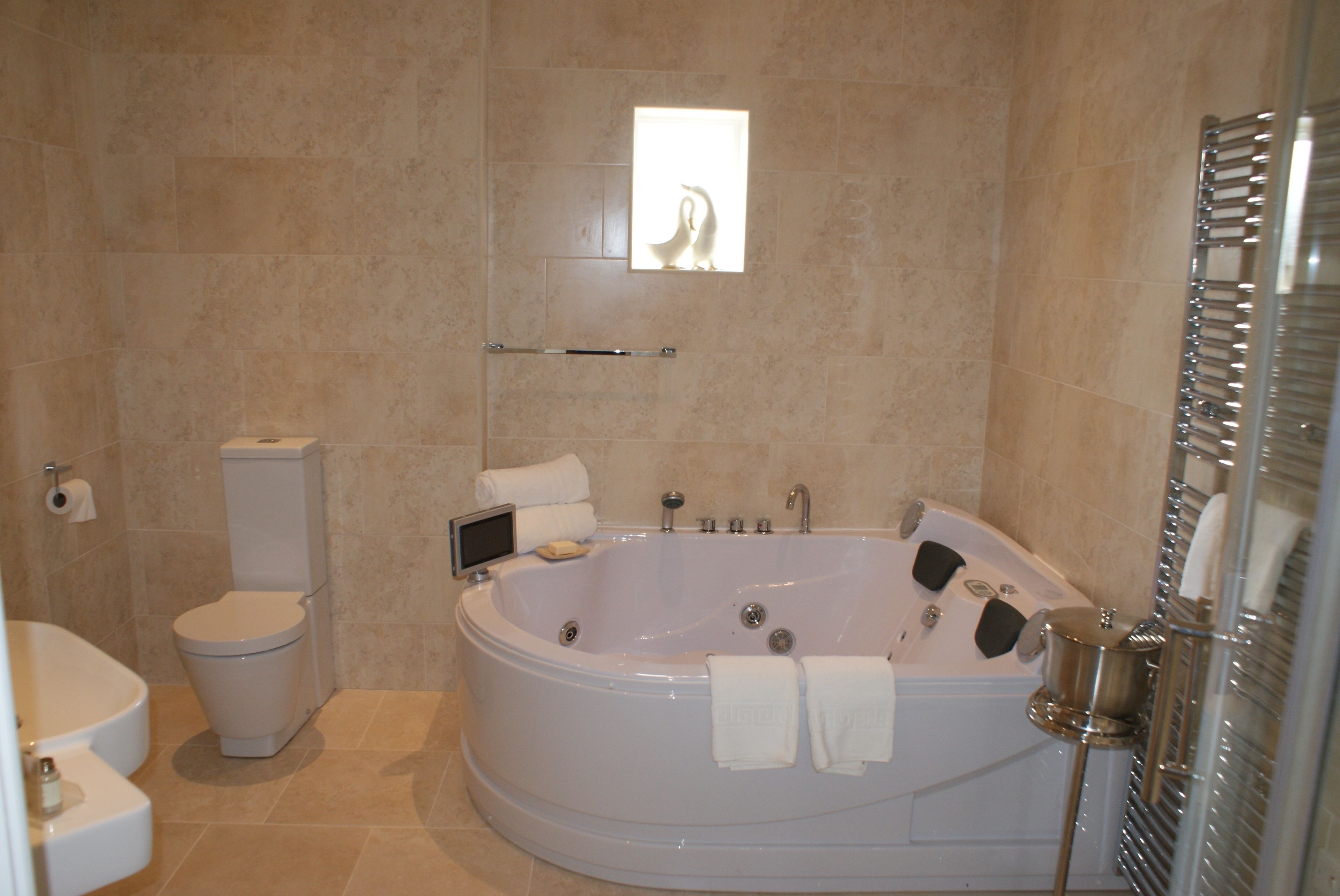 A bathroom with a toilet, a bathtub, and a shower area.