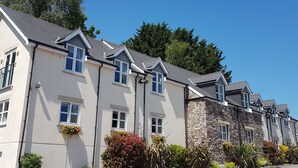 A row of modern, two-story buildings with a uniform architectural style, featuring large windows and a mix of stone and plaster exteriors. - The Old Barn Inn (Newport)