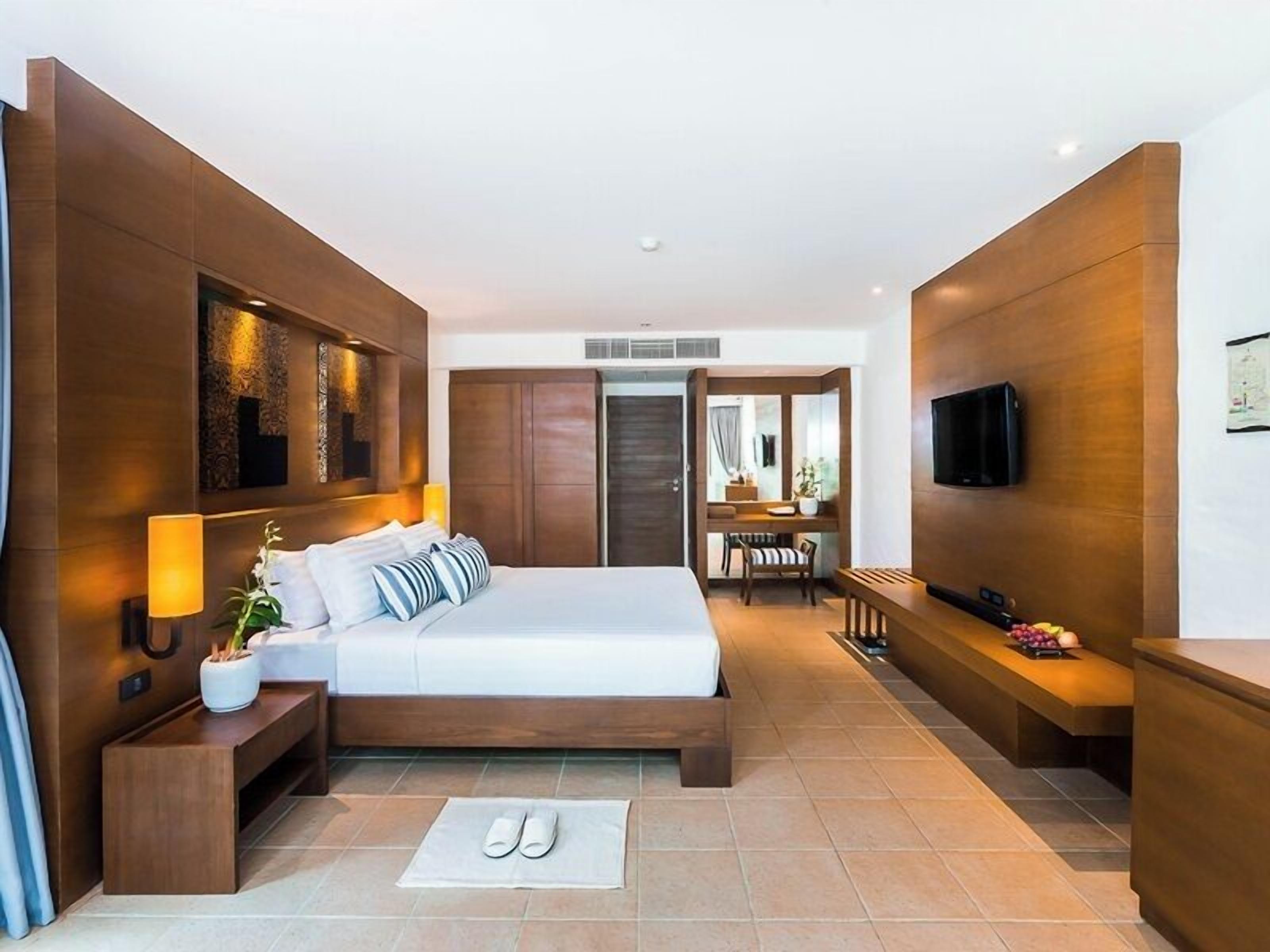 Une chambre d’hôtel moderne équipée d’un grand lit, d’un bureau, d’une télévision et d  ’une salle de bain.