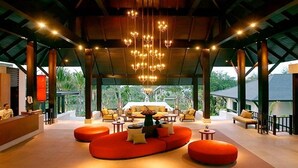 A spacious lobby with a modern design, featuring a large seating area with orange sofas and a reception desk. - Pattaya Sea Sand Sun Resort & Spa (Pattaya)