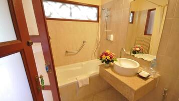 A bathroom with a bathtub, a sink, and a mirror.