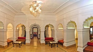 A grand hall with ornate arches, a chandelier, and seating areas. - Neemrana's Baradari Palace (Patiala)