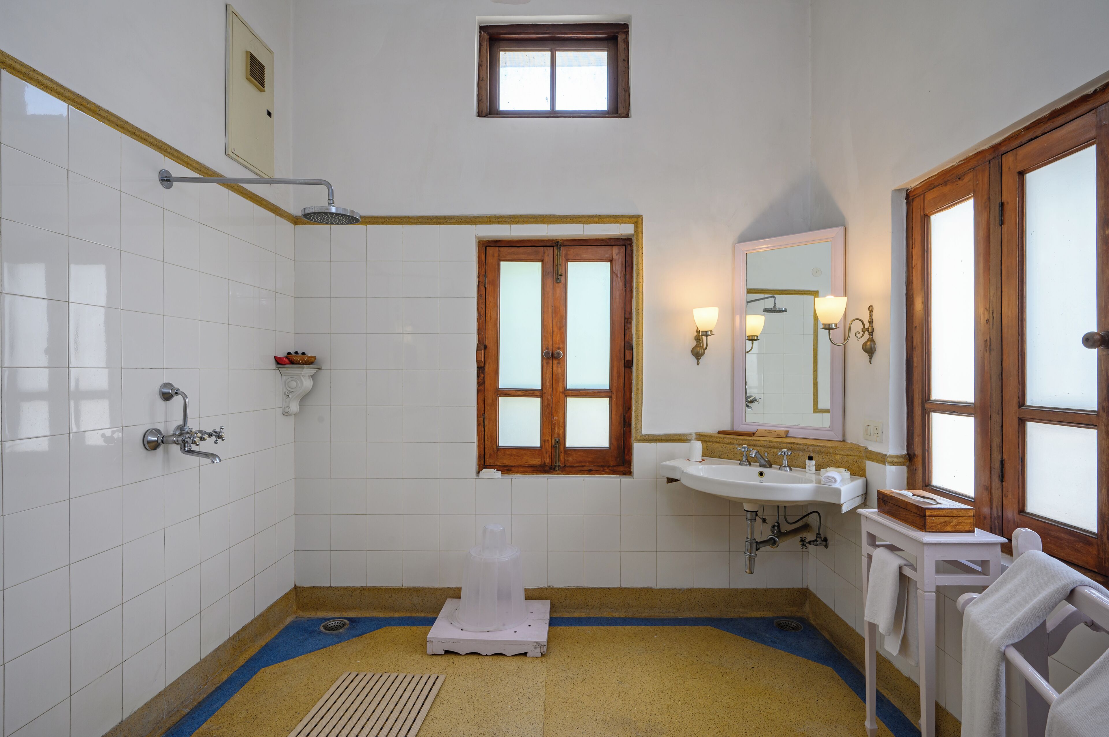 A bathroom with a shower, sink, and a window.