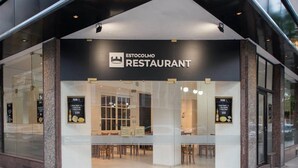 A restaurant with a modern facade, large glass windows, and a sign indicating it is a restaurant. - Estocolmo Hotel (Mar del Plata)