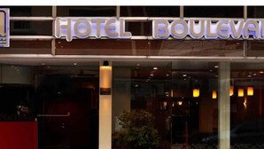 L’entrée d’un hôtel, avec une enseigne indiquant « HÔTEL BOULEVARD ».