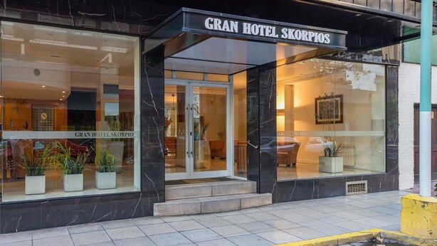 El exterior del Gran Hotel Scorpio, con un diseño moderno, presenta amplios ventanales y una fachada de mármol.