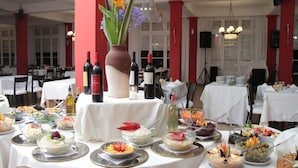 A buffet setup with various dishes and a wine selection.