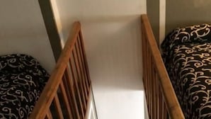 A wooden staircase with a white handrail leading to a landing.