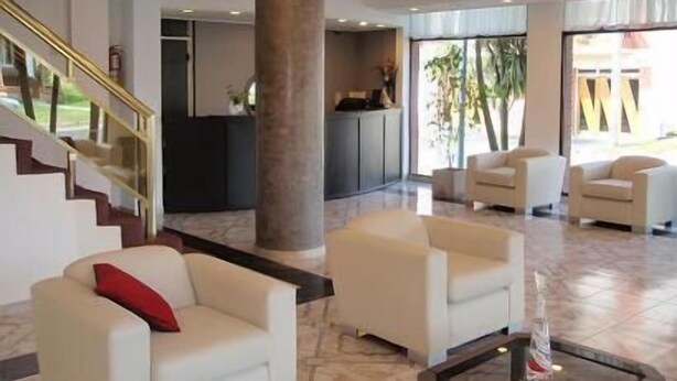 A modern lobby with a staircase, seating area, and reception desk. - Montecarlo Hotel (Mar del Plata)