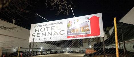 A private hotel sign with a red arrow pointing upwards, indicating the hotel's location at La Rioja 1339.