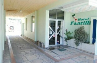 Una entrada de hotel con un camino empedrado que conduce a una puerta de vidrio.