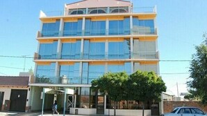 A multi-story building with large windows and a flat roof. - Hotel Fantilli (Puerto Madryn)