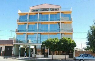 Un edificio de varios pisos con grandes ventanales y techo plano.