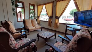 A living room with a sofa, armchairs, a coffee table, and a television. - Patagonia Apart Hotel (Puerto Madryn)