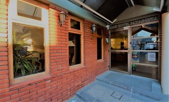 Un edificio de ladrillo con un cartel que dice "APART HOTEL PATAGONIA" y una puerta con un ventanal.
