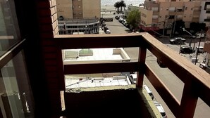 A balcony with a view of a cityscape, including buildings and a clear sky. - Patagonia Apart Hotel (Puerto Madryn)