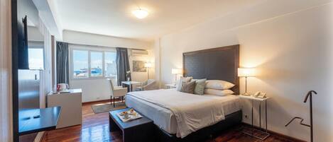 Camera d'albergo con un letto grande, comodini, una scrivania, una sedia e vista sulla città.
