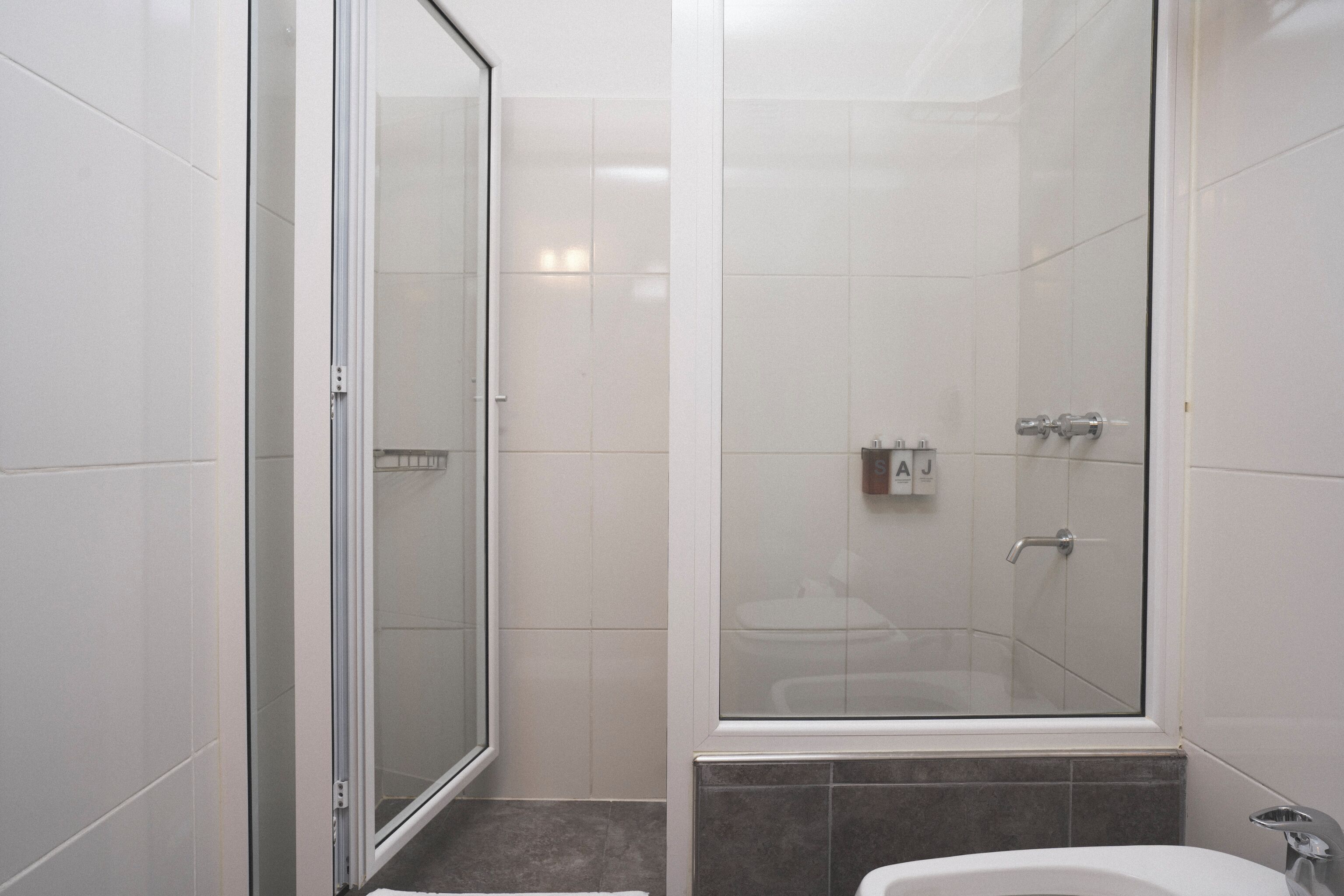 Ein modernes Badezimmer mit Duschkabine, Badewanne und Toilette.