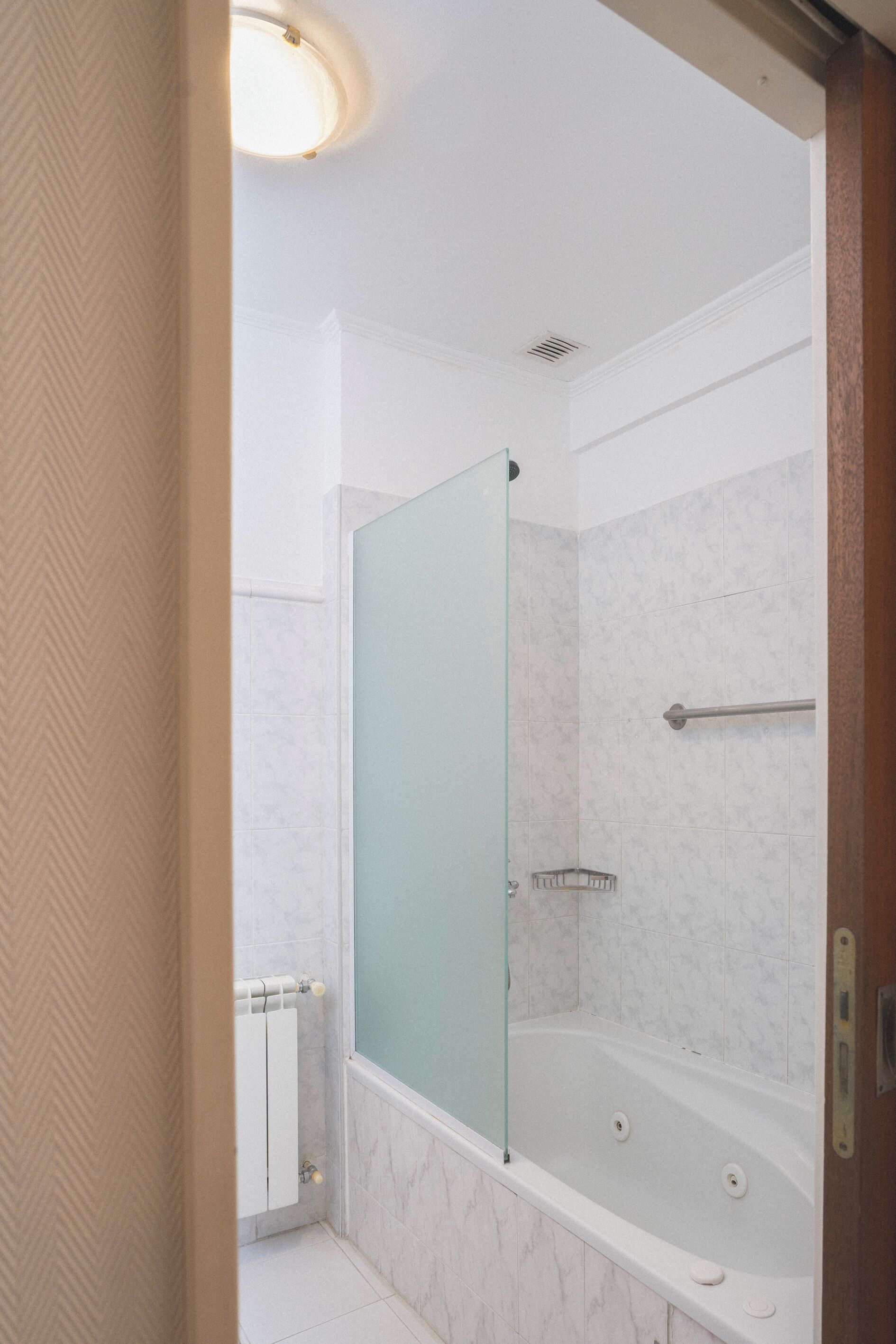 A bathroom with a glass shower enclosure, a bathtub, and a toilet.