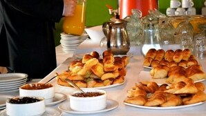 A breakfast buffet with various pastries, jams, and a coffee pot. - Opera Hotel (Rio Cuarto)