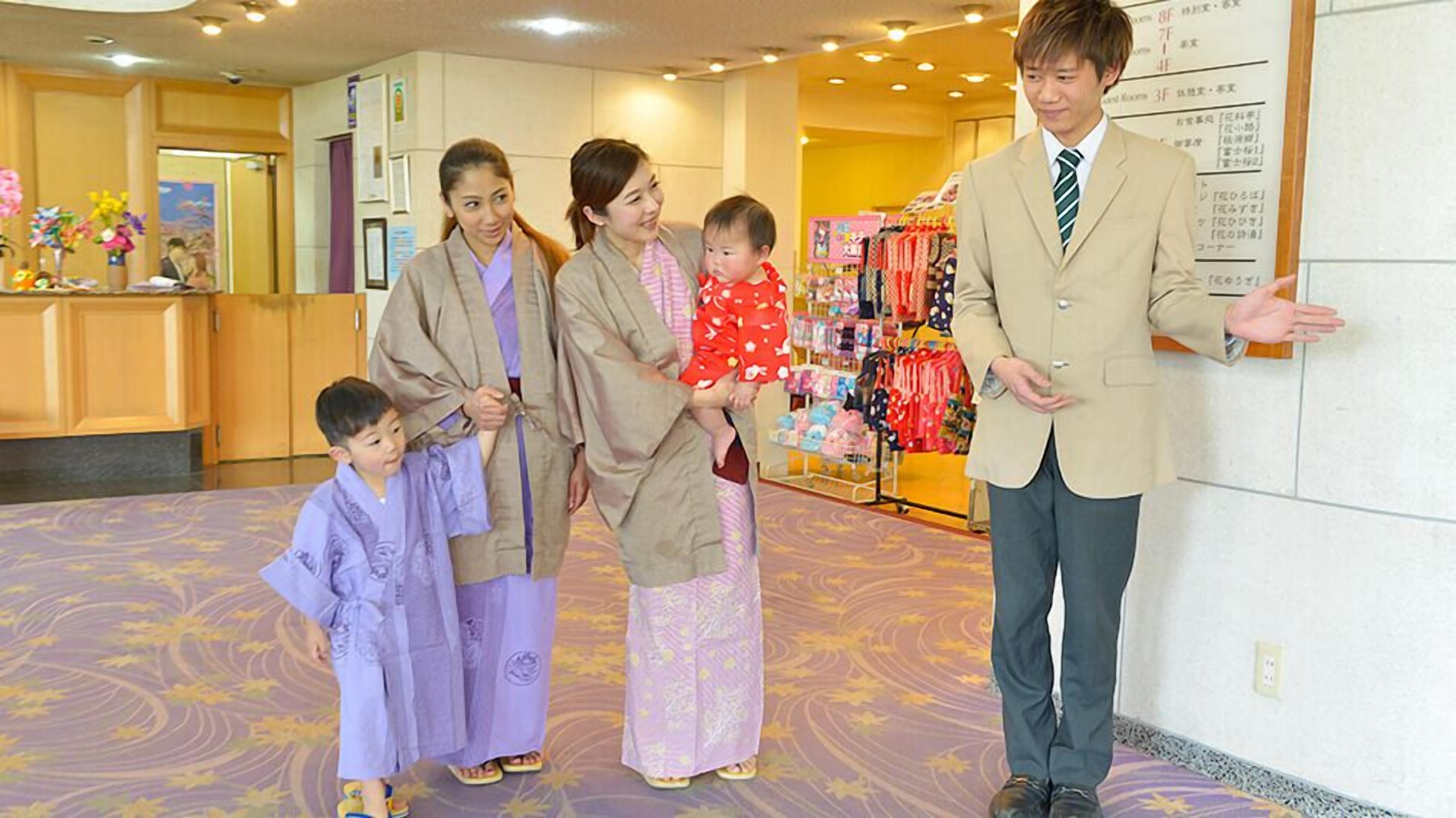 A hotel lobby with a reception desk, a wall with a menu, and a clothing display.