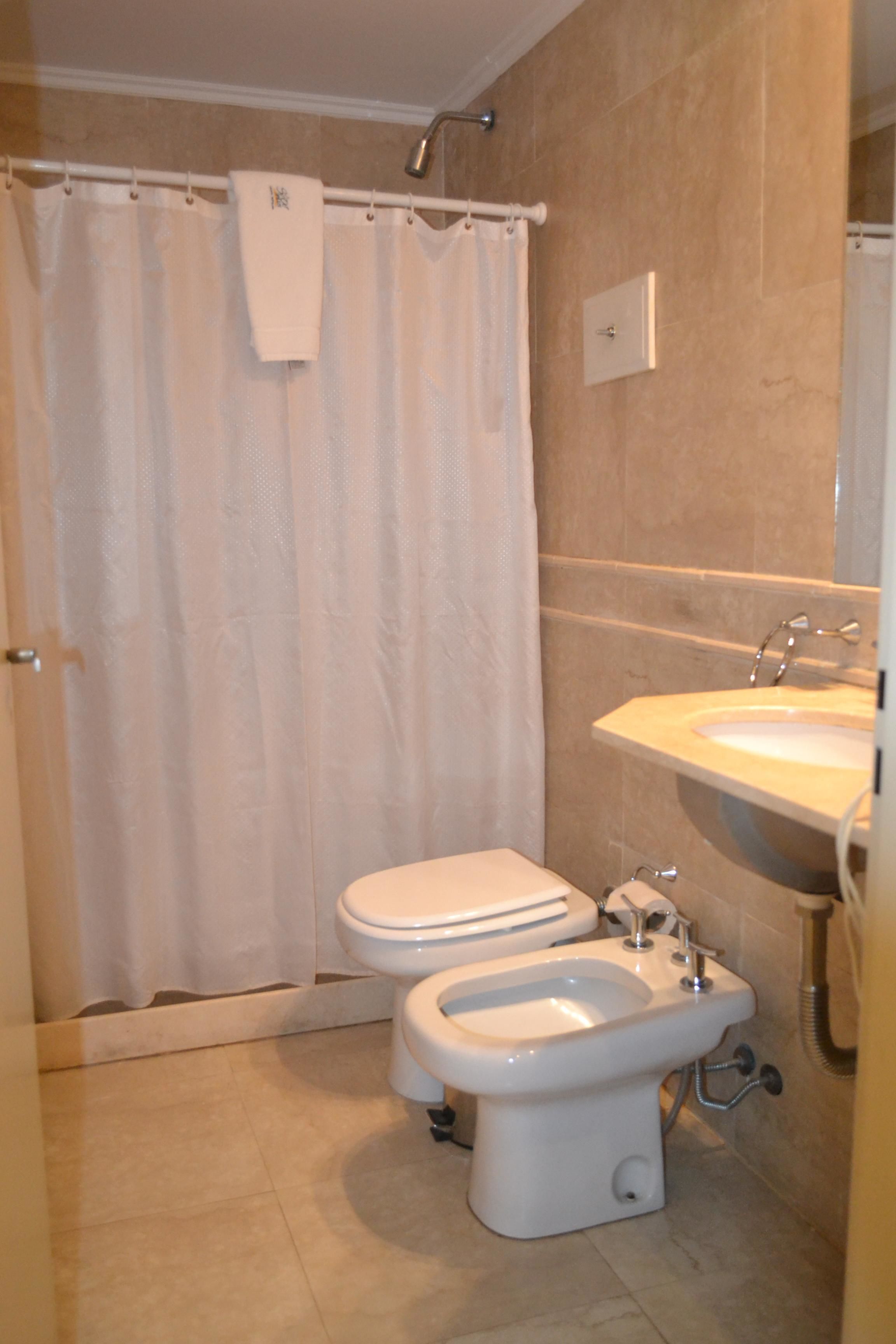 A bathroom with a toilet, bidet, and sink.