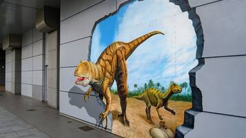 A mural of dinosaurs on a building wall.