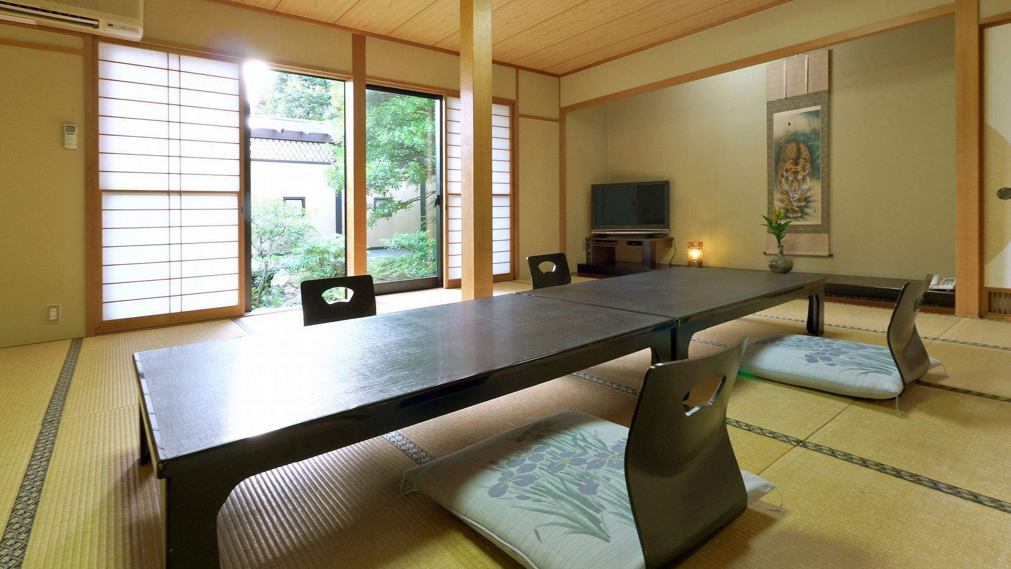 A traditional Japanese room with tatami flooring, a low table, and sliding doors.
