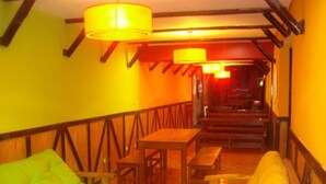 A cozy interior with a wooden staircase, a green sofa, a yellow sofa, and a table with a lamp. - Hostel Campo Base (Mendoza City)