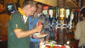 A bar area with bottles of liquor, condiments, and a plate of food. - Hostel Campo Base (Mendoza City)