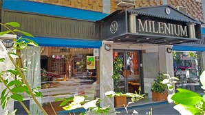 Ein Schaufenster mit einem Schild, auf dem 'MILENIUM' steht.