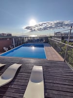 Piscina en la azotea con vistas despejadas al cielo y edificios cercanos.