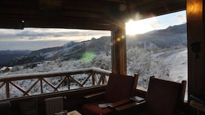 Une cabane en bois offrant une vue sur un paysage enneigé.