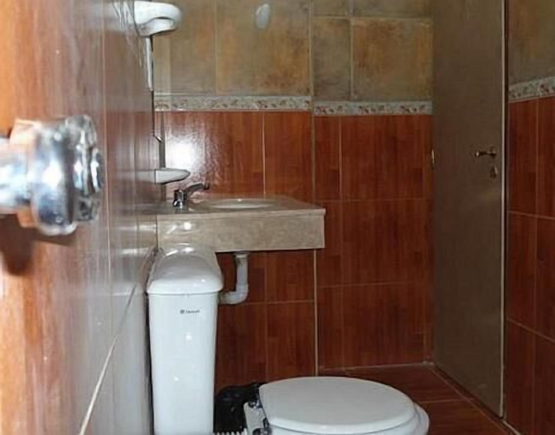 Un baño pequeño con inodoro, lavamanos y calentador de agua.