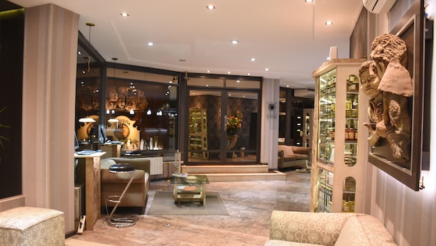 Um interior moderno com área de estar, uma vitrine de vidro e uma escultura decorativa.